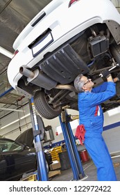 Low Angle View Of Middle-aged Mechanic Working Under Car