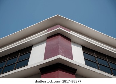Low angle view of modern building roofline corner against blue sky.