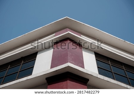 Low angle view of modern building roofline corner against blue sky.