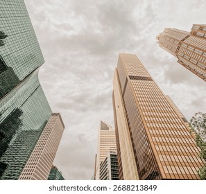 Low angle view of modern skyscraper buildings reaching to a soft cloudy sky.  Located in the downtown Loop in Chicago, Illinois on the Chicago River.