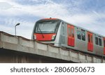 Low angle view of a modern subway train moving on an elevated concrete bridge.