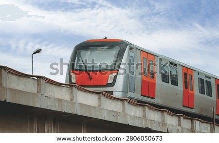 Low angle view of a modern subway train moving on an elevated concrete bridge.