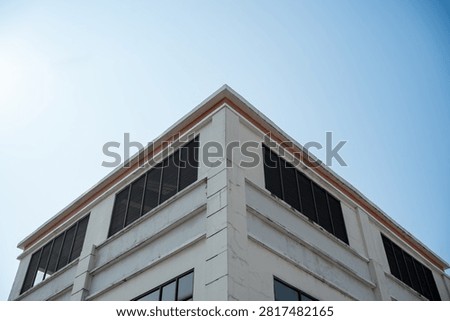 Low angle view of modern white building corner against clear blue sky.