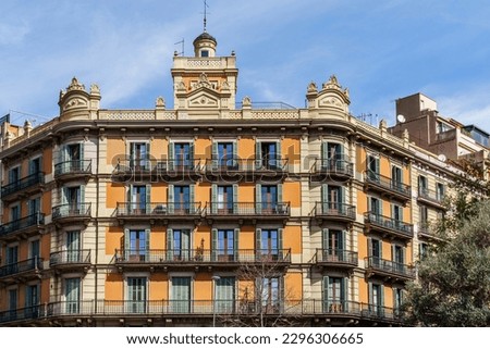 A low angle view of a modernist building in Barcelona, Spain, with its grand facade windows against the sky of an estate neighborhood.