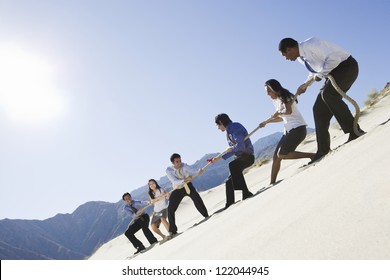 Low Angle View Of Multi Ethnic Business People Playing Tug Of War In Desert