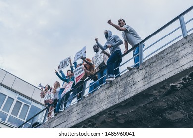 low angle view of multicultural people screaming and gesturing while holding placards 
