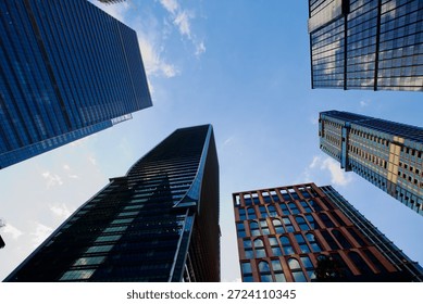 Low angle view of multiple modern buildings rosed up in the blue sky,Bangkok Thailand.