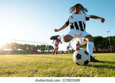 Low Angle View Of Multiracial Player Kicking Ball While Playing Soccer Match Against Clear Sky. Playground, Summer, Copy Space, Summer, Rivalry, Effort, Unaltered, Soccer, Competition And Sport.