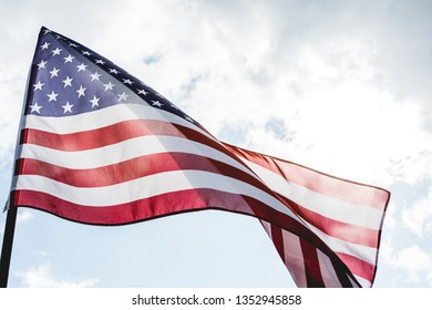 low angle view of national american flag with stars and stripes against sky with clouds  - Shutterstock ID 1352945858