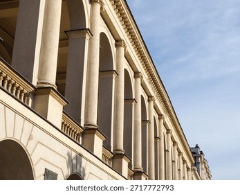 Low angle view of the neo-classical facade of a historic European government or palace building with columns.