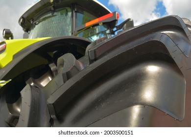 Low Angle View Of A New Farm Tractor With A Close-up Of An Agricultural Tractor Tire.