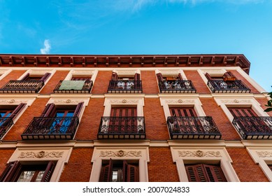 Low angle view of old recently renovated residential building against blue sky. Madrid, Spain
