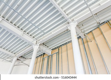 Low angle view on structure girders with metal skeleton at indoor ceiling construction. 