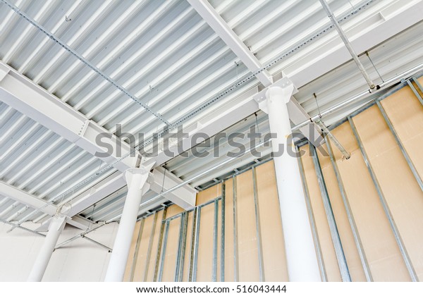 Low angle view on structure\
girders with metal skeleton at indoor ceiling construction.\

