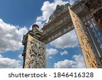 Low angle view of one of the iron entrance gates to the Dolmabahce Palace in Istanbul, Turkey against white clouded blue sky