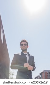 low angle view, one young man buttoning suit sunglasses, sky day Sun