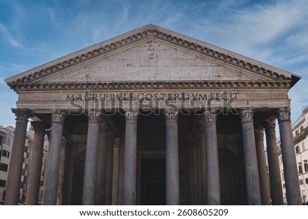 Low angle view of the pantheon's facade in rome, italy, showcasing classical architecture with corinthian columns, a triangular pediment, and the inscription under a vibrant blue sky