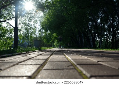 Low angle view of pavement with young caucasian girl playing in background out of focus