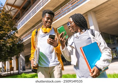 Low angle view photo of male and female african american university friends using phones walking along the campus - Powered by Shutterstock