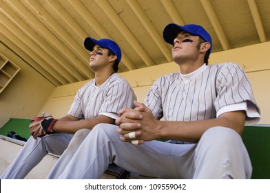 Low angle view of players watching the game intensely while sitting in dugout