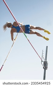 Low angle view pole vaulter clearing bar