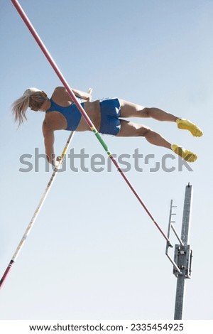Low angle view pole vaulter clearing bar