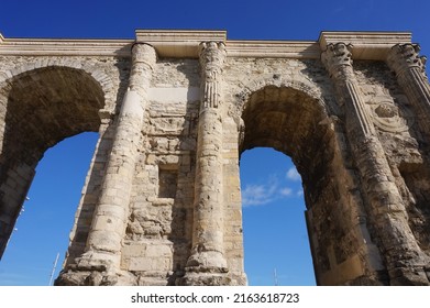 Low angle view of the Porte de Mars (Gate of Mars), a 3th century vestige, and an ancient Roman triumphal arch, located at the end of the Hautes Promenades, in Reims, in the Northeast of France - Shutterstock ID 2163618723
