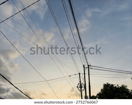 Low angle view of power lines against a soft pastel sunset sky