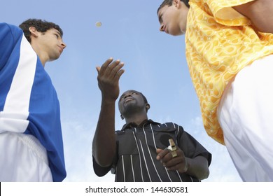 Low Angle View Of Referee Flipping A Coin Before The Football Game