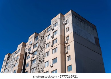 Low angle view of residential panel building facade against clear blue sky in Ukraine