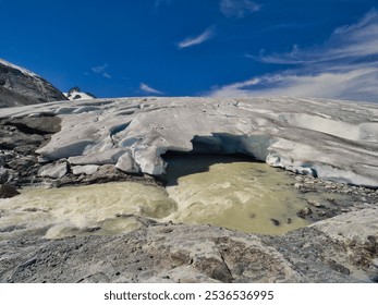 Low angle view of retreating glacier against deep blue summer sky
