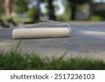 Low angle view of roller on concrete driveway during sealing with background blur
