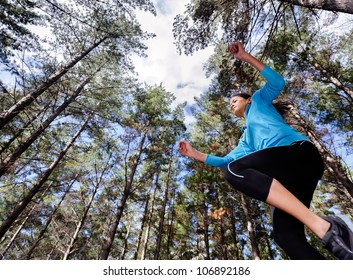 low angle view of runner jumping and running in forest. healthy active lifestyle