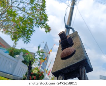 Low angle view rusty steel wire rope and metal cable clamp connected with screw bolt in sidewalk - Powered by Shutterstock