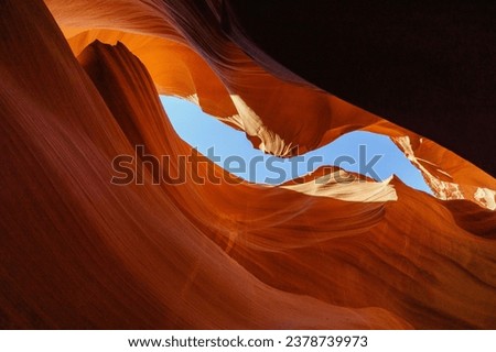 Low angle view of sandstone and red rock with texture against blue sky at Antelope Canyon, Arizona, USA
