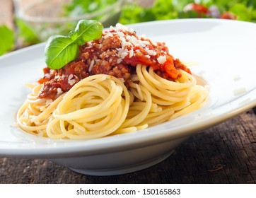 Low angle view of a serving of Italian spaghetti with a meat based bolognese, or bolognaise, sauce on a plain white plate