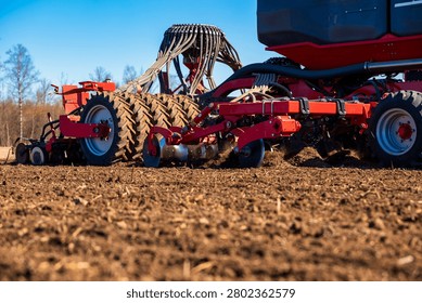 Low angle view shows a modern air seeder and cultivator at dawn in an open field, leafless trees beyond, crisp light, disc openers, gauge wheels, and hydraulic linkages.
