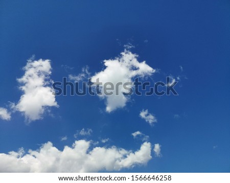 Low angle view The sky is blue with white clouds of vertical development scatter.Imagine being the face with eyes and mouth.