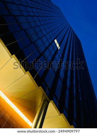 Low angle view of skyscraper at night with only one window light on
