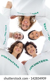 Low angle view of a smiling group of volunteers on white background