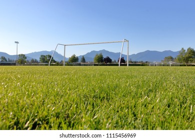 Low Angle View Of A Soccer Pitch With Goal Posts In A Rural Valley Setting. 