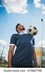 Low Angle View Of Soccer Player Training With Ball On Soccer Pitch