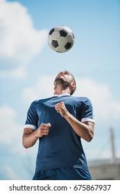 Low Angle View Of Soccer Player Training With Ball On Soccer Pitch