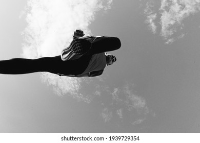 Low angle view of a sportsman who jump and run with blue sky in background - Powered by Shutterstock