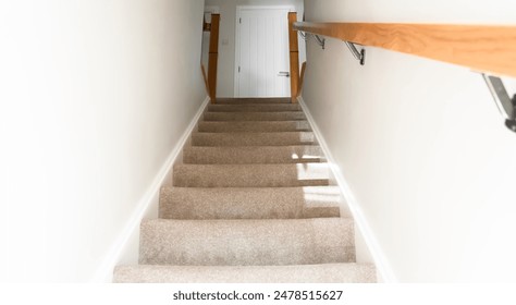 Low angle  view of Staircase in the modern house with brown carpet and stained solid wood decoration on white concrete wall ,Empty indoor steps stair walk through upstair with bright sunlight  - Powered by Shutterstock