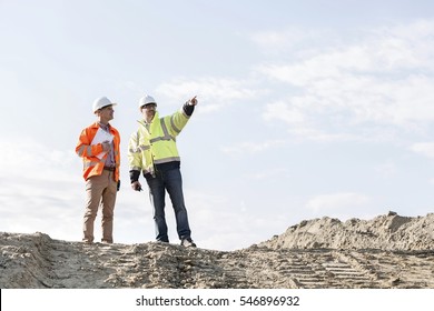 Low Angle View Of Supervisor Showing Something To Colleague At Construction Site