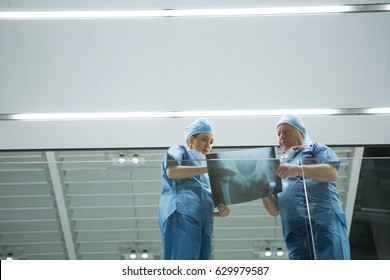 Low angle view of surgeons discussing x-ray in corridor of hospital. Healthcare workers in the Coronavirus Covid19 pandemic
