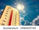 low angle view Thermometer on blue sky with sun shining in summer show higher Weather, concept global warming, climate change