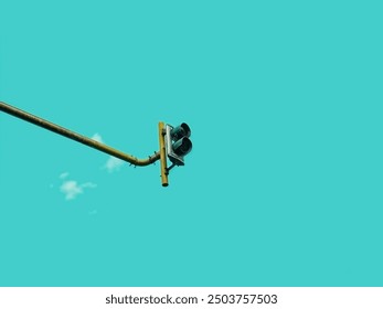 Low angle view of traffic light and metal pole against the sky
