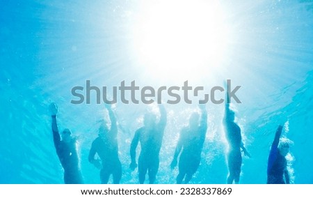 Low angle view triathletes in wetsuits underwater